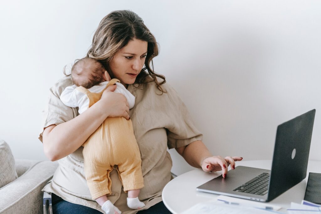 mother working at home carrying a baby image