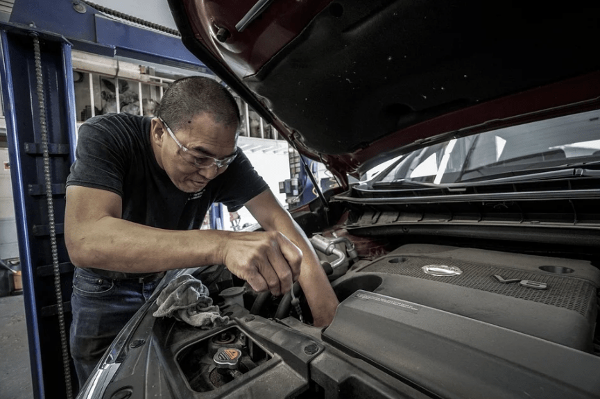 a car mechanic inspecting the engine of a car