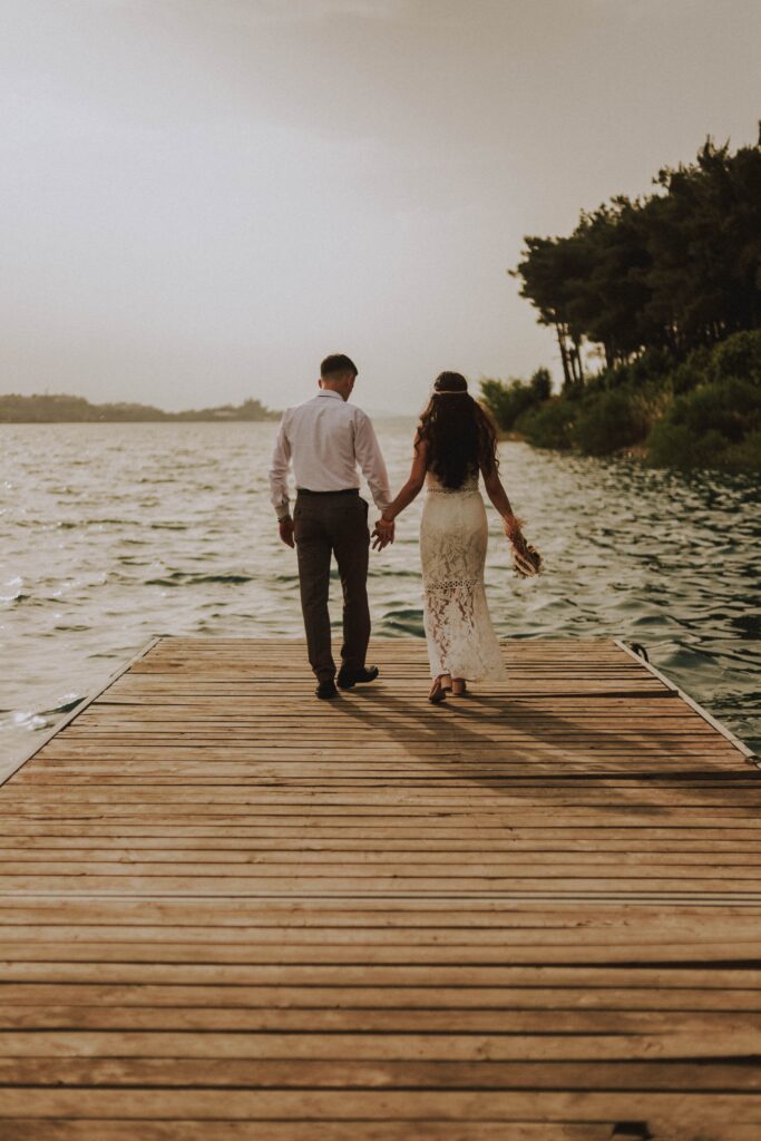A bride and groom near a lake image