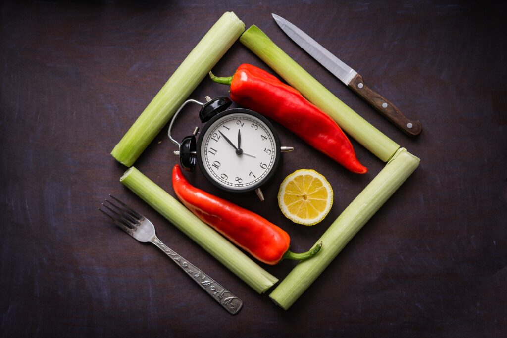 A clock surrounded by food and utensils image