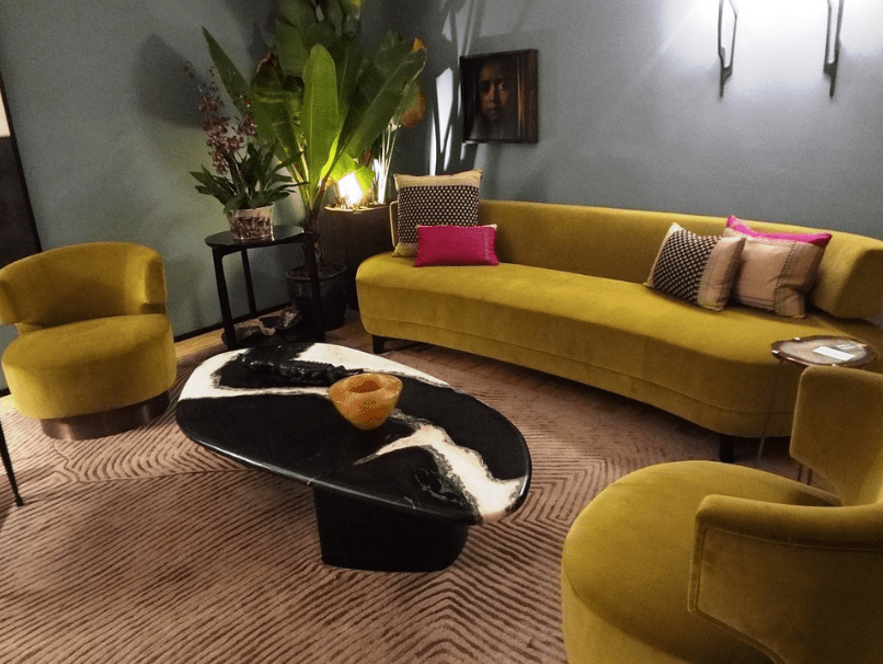 A living room with velvet mustard yellow couches
