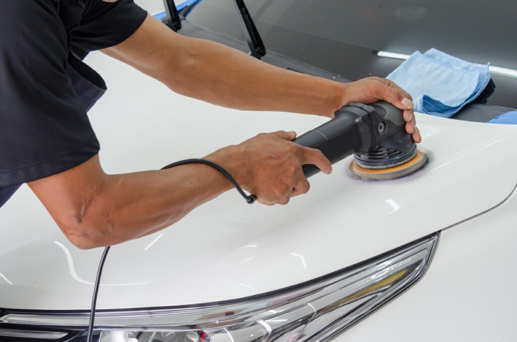 a person polishing the white car image