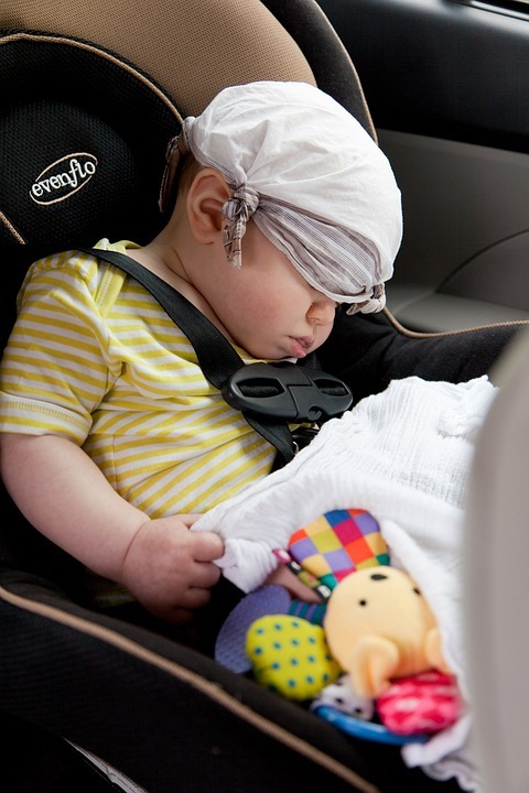 baby sleeping in a car seat while travelling