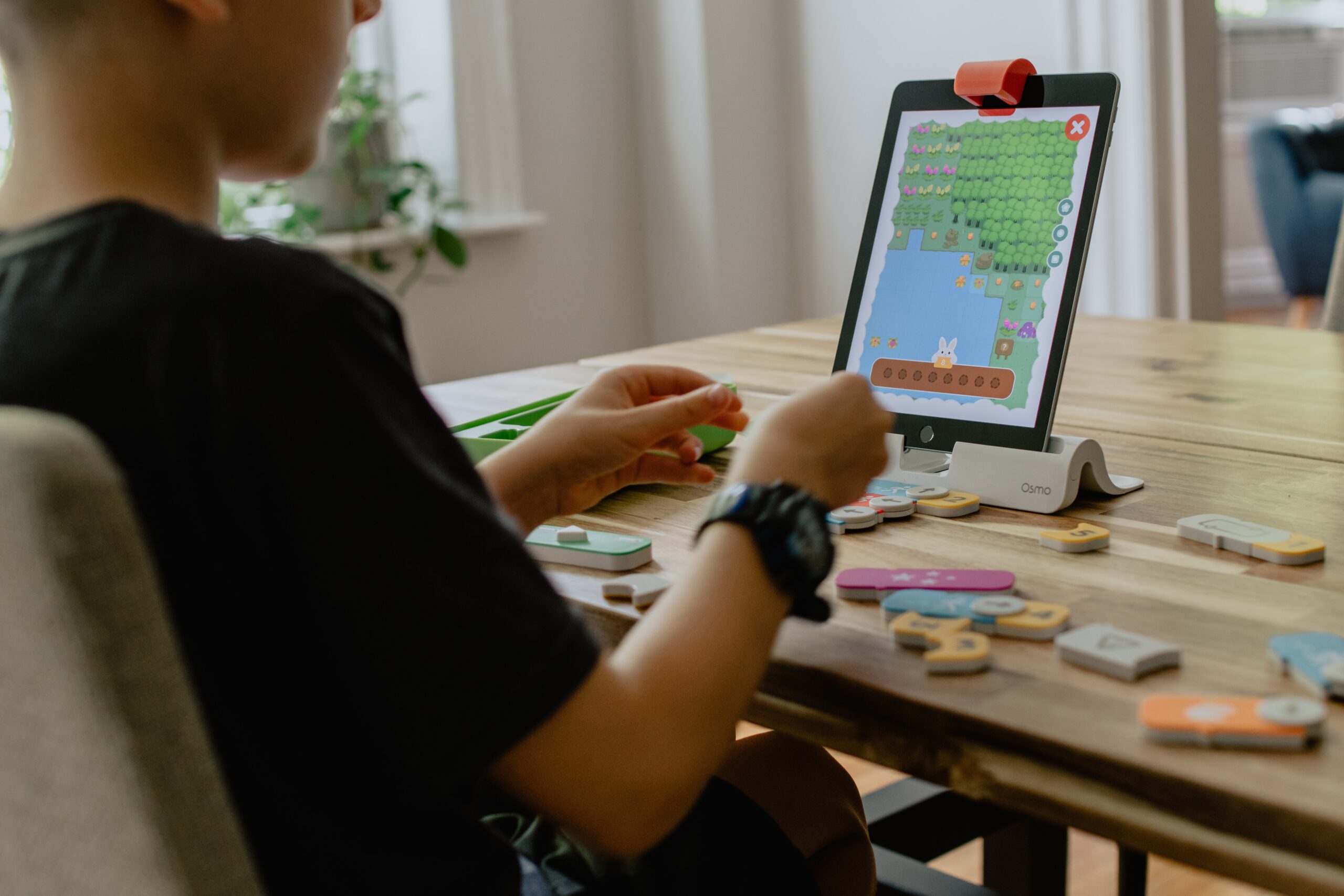 An image of a A kid learning coding through an iPad