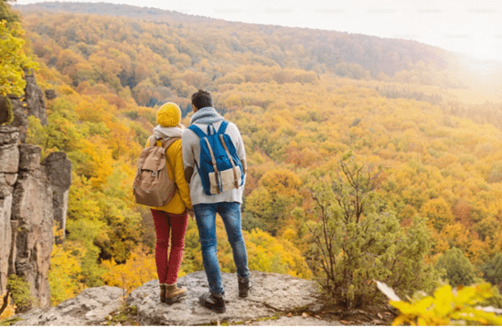 Beautiful young couple on a walk in autumn forest