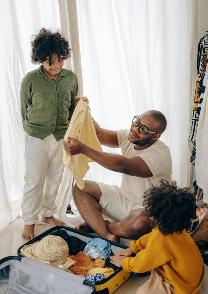 father with kids packing suitcase image
