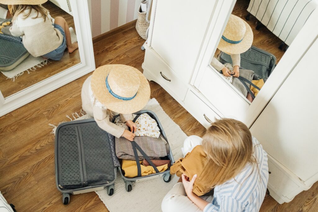 girl packing with mom looking on image