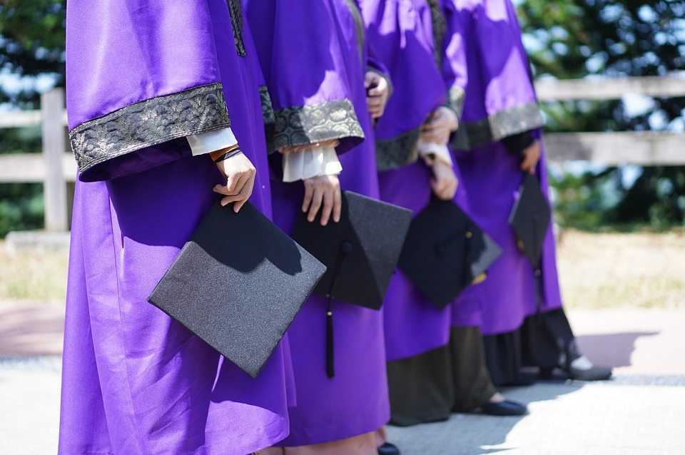 graduates holding diploma image