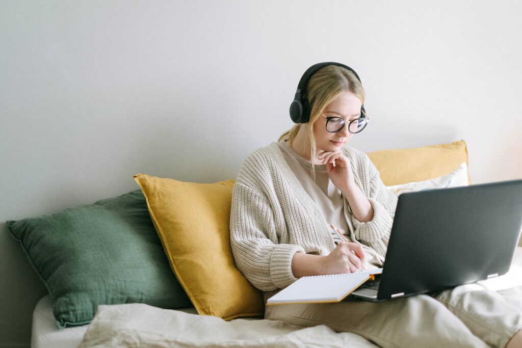 woman on earphones with laptop image
