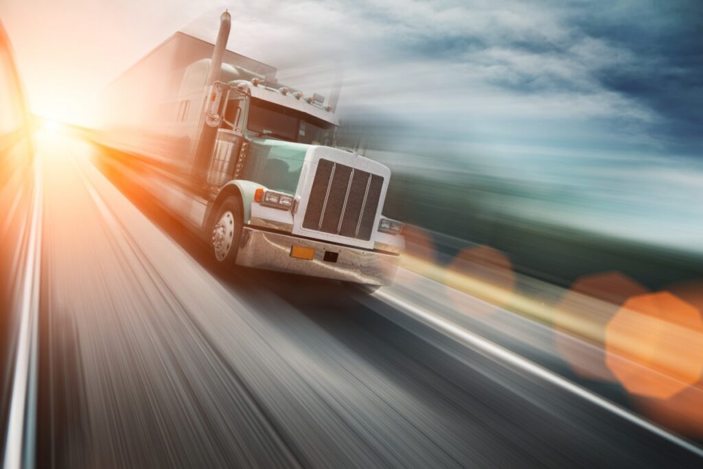 A moving truck moving at high speed on a road image