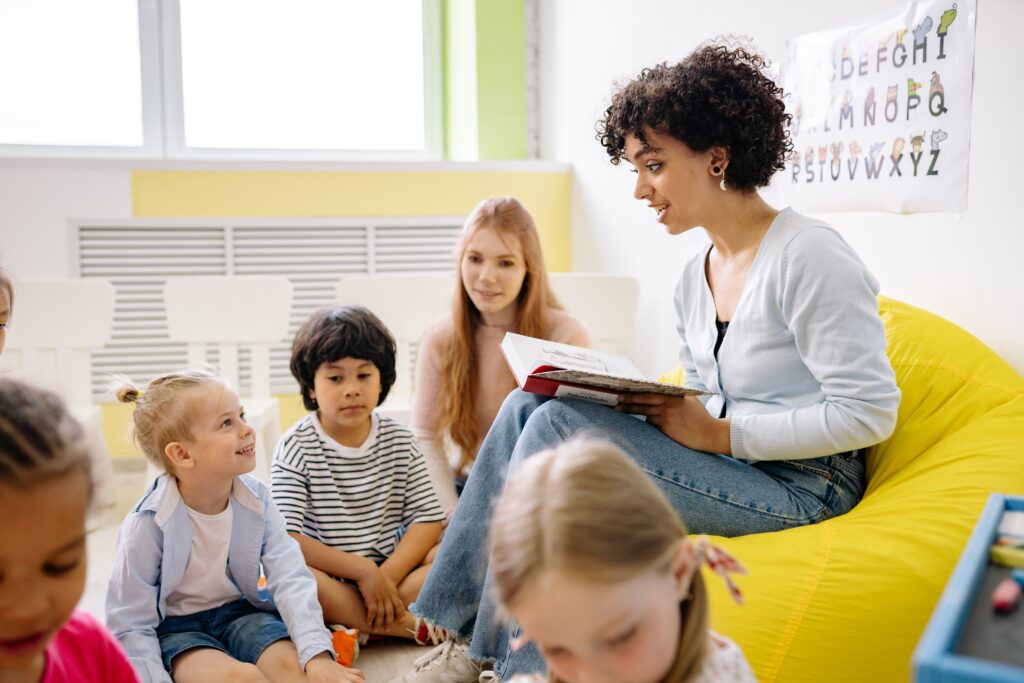woman reading a book to the children image