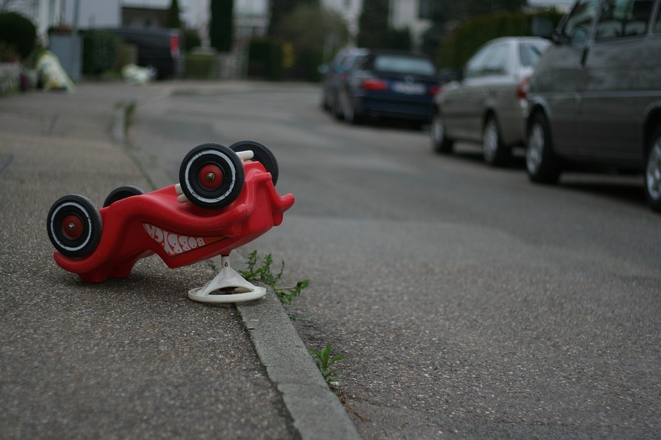An overturned red toy car image