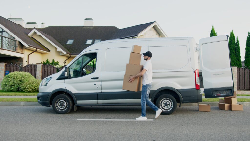 Man Carrying Boxes Beside a Van image