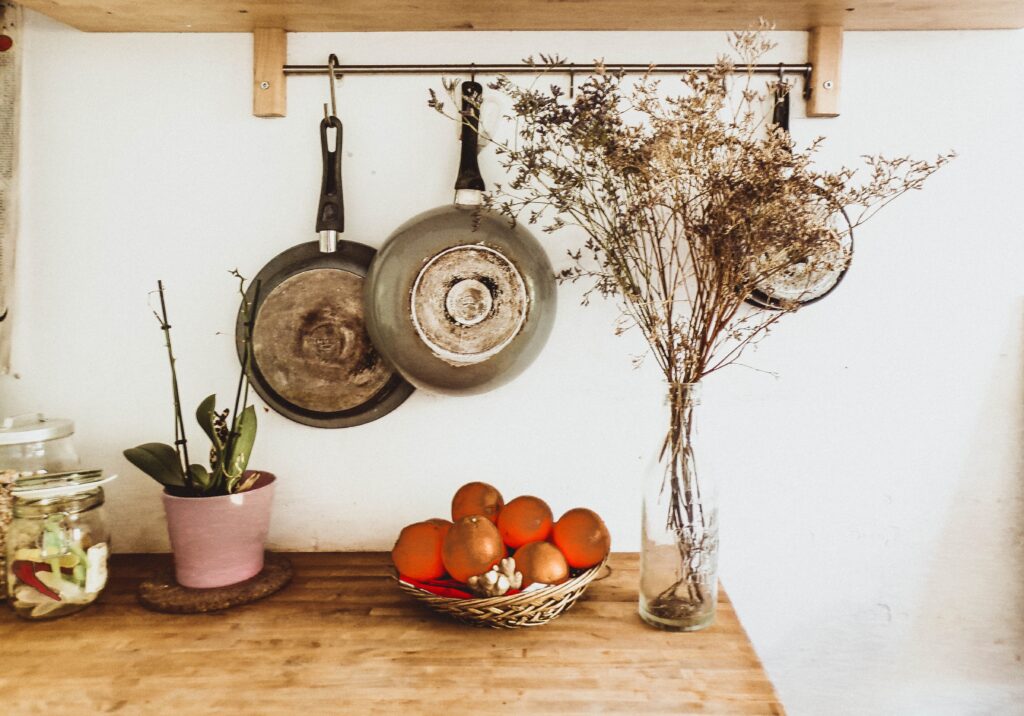 Two gray frying pans hanging on wall image