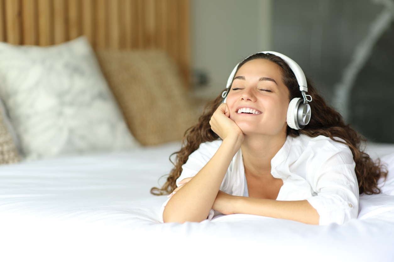 a happy woman listening to music on headphones