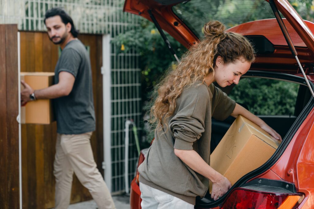 couple unpacking car while moving to new place image