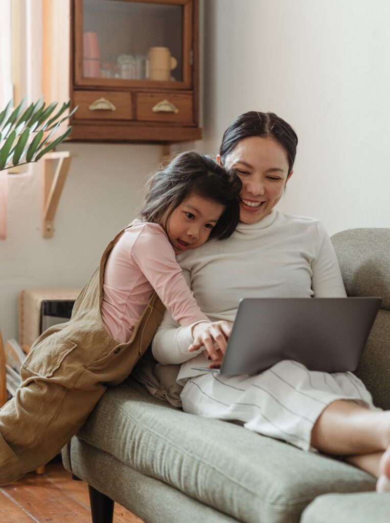 mother using laptop with daughter image