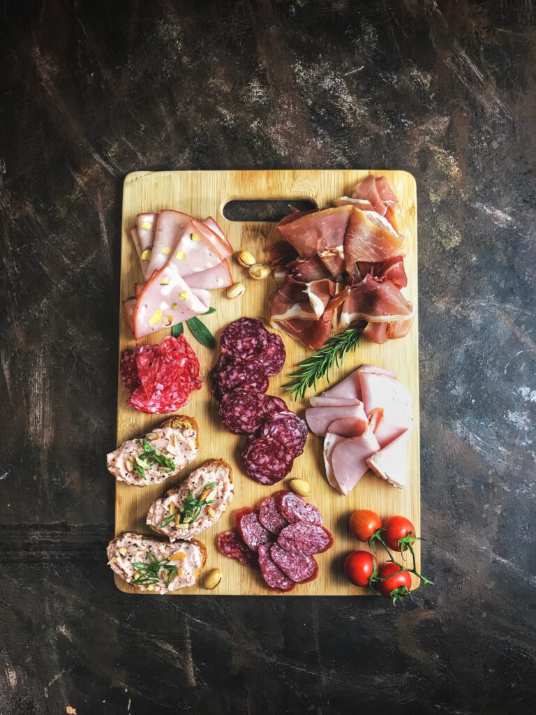 sliced meats on a wooden chopping board image