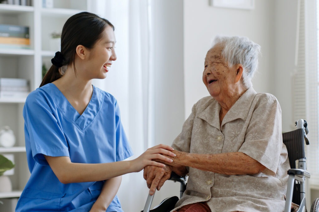 A young caregiver talking with a senior woman in a wheelchair