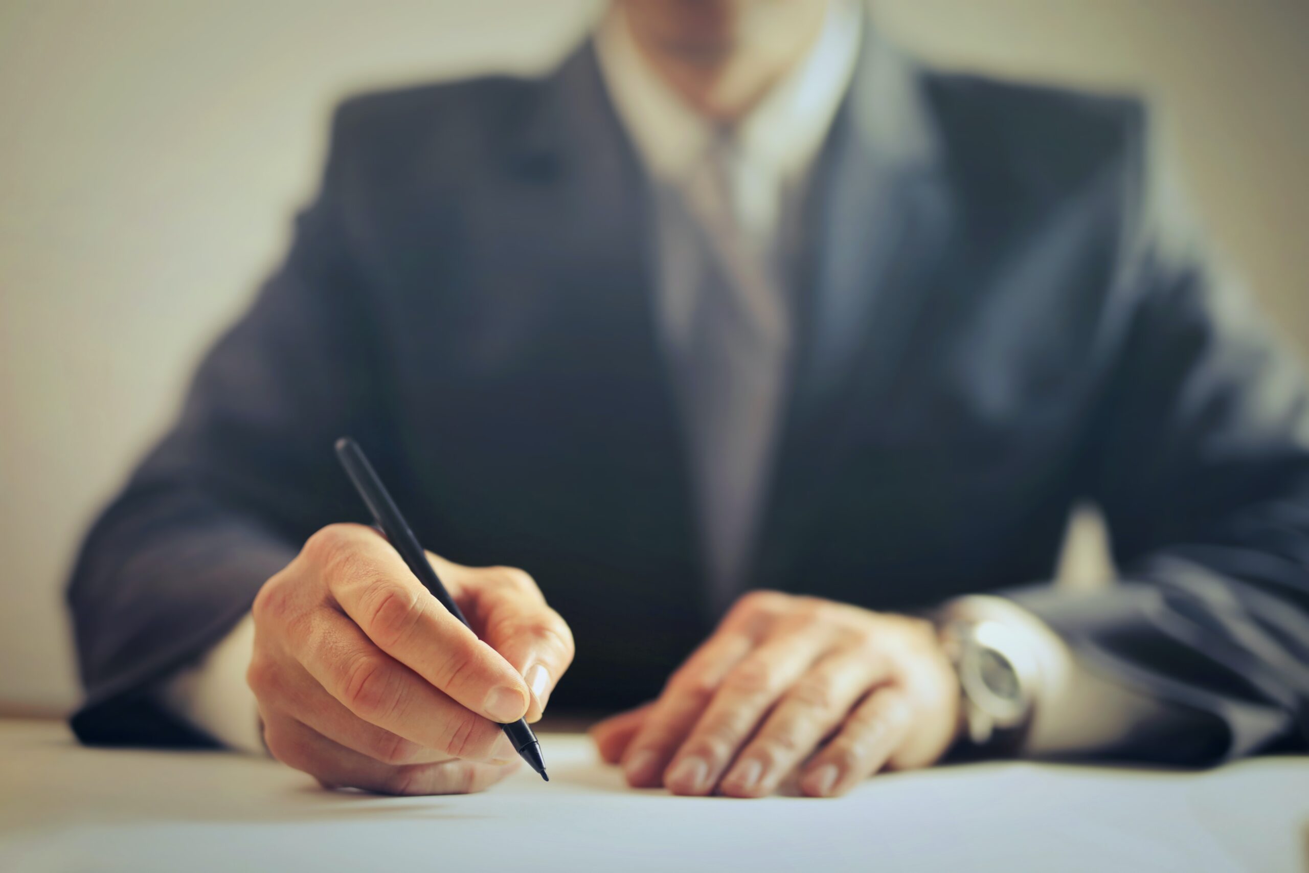 A man in a suit signing a contract image