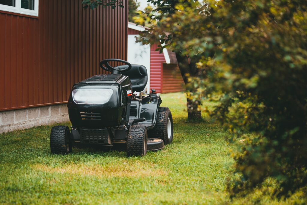 lawn mower on green grass field during daytime image