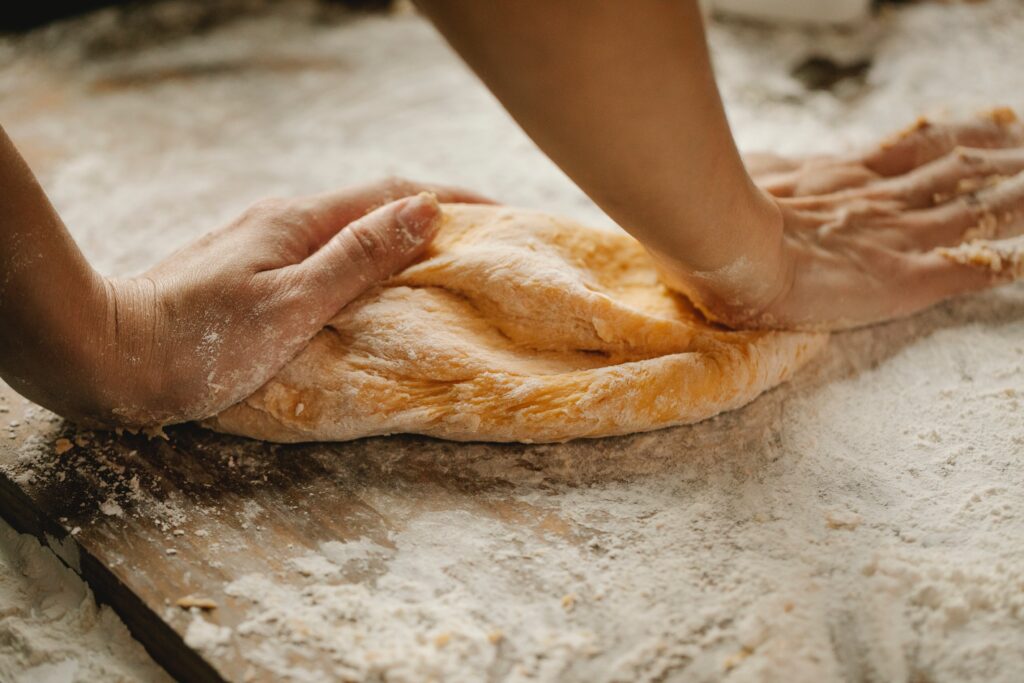 Chef making fresh pastry on table in bakery image