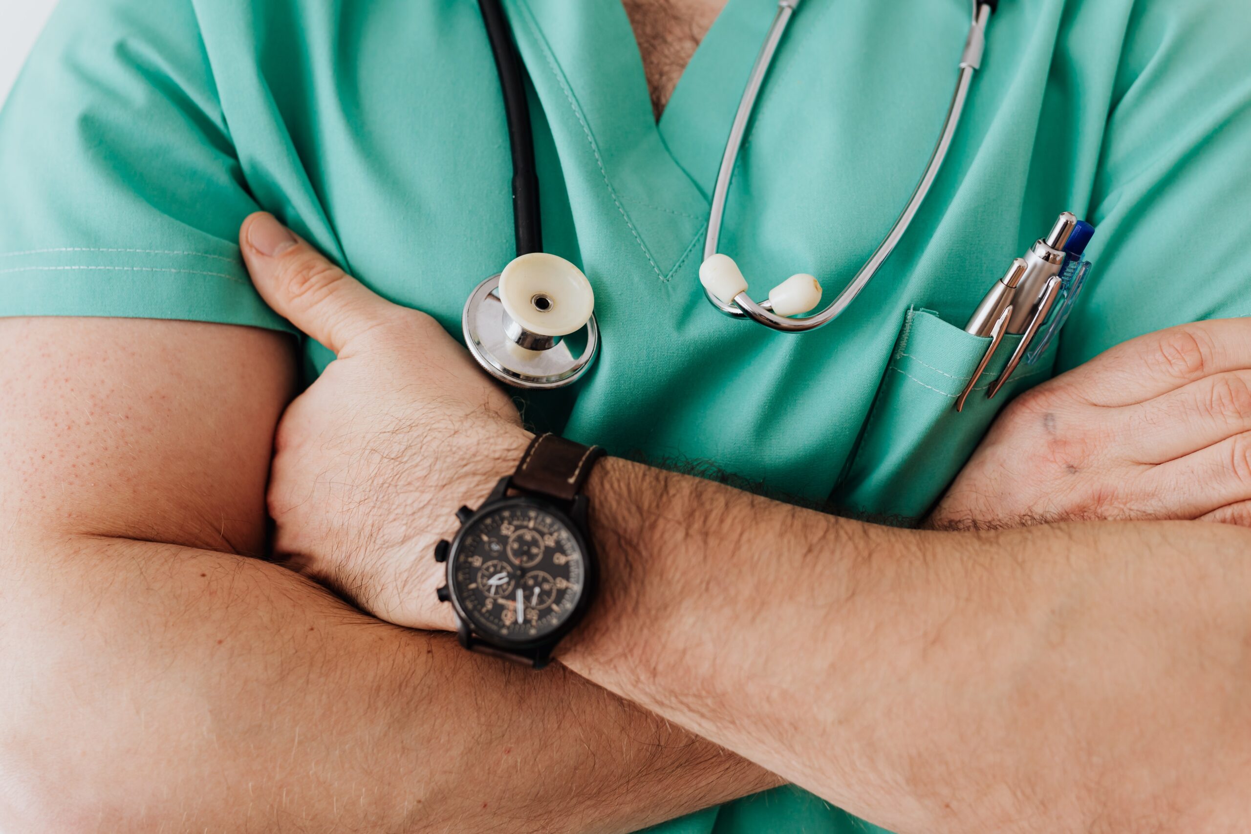 Closeup image of a male doctor wearing a watch and a stethoscope