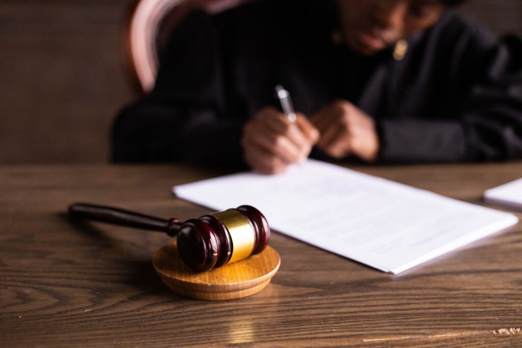 table with gavel and judge signing a document image
