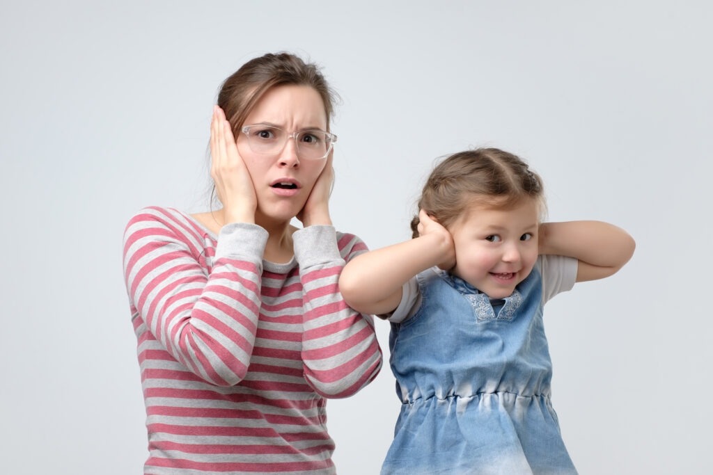 woman and her little daughter cover their ears image