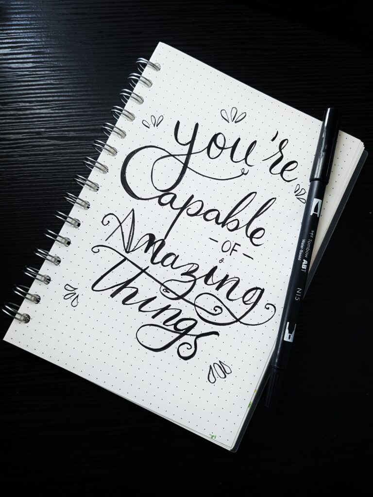 A quotation on a notebook saying you’re capable of doing amazing things image