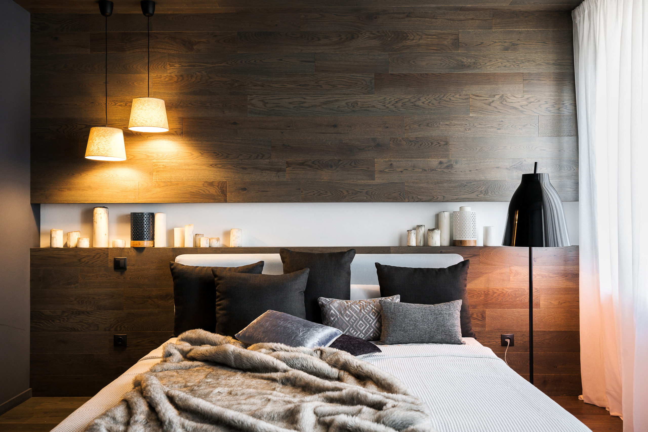 The interior of a stylish bedroom in dark colors. Wooden walls,