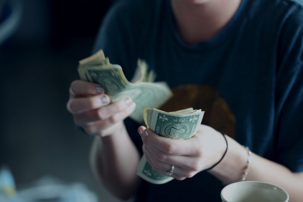 Focus photography of a person counting dollar banknotes photo