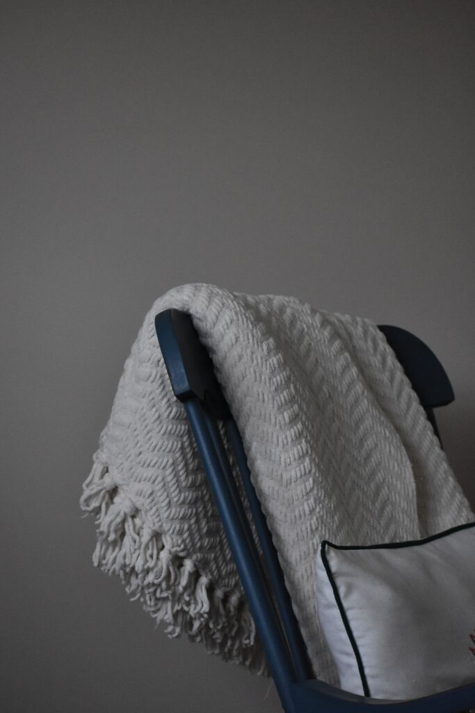  soft lighting of a chair and textured white blanket image
