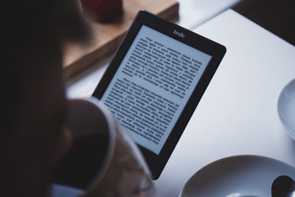 person using ebook reader while drinking coffee image