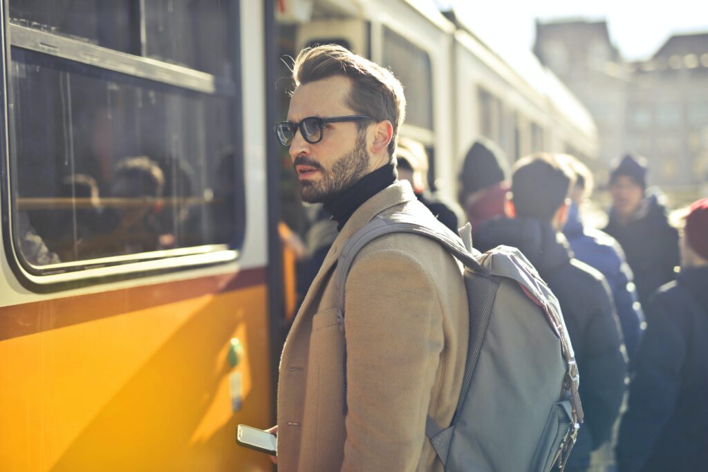 A man wearing a backpack near a train image