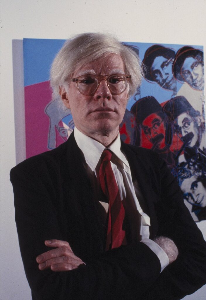 Warhol posing for a picture wearing a suit at the Museum  image