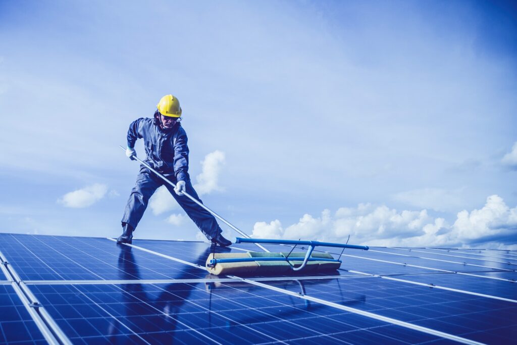 an image of a man cleaning a solar panel