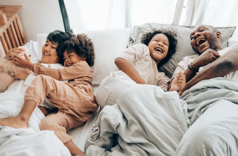 happy-multiracial-family-having-fun-together-in-bed