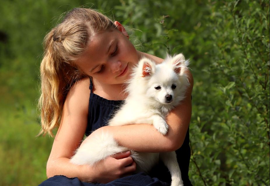 girl cuddling a pet dog