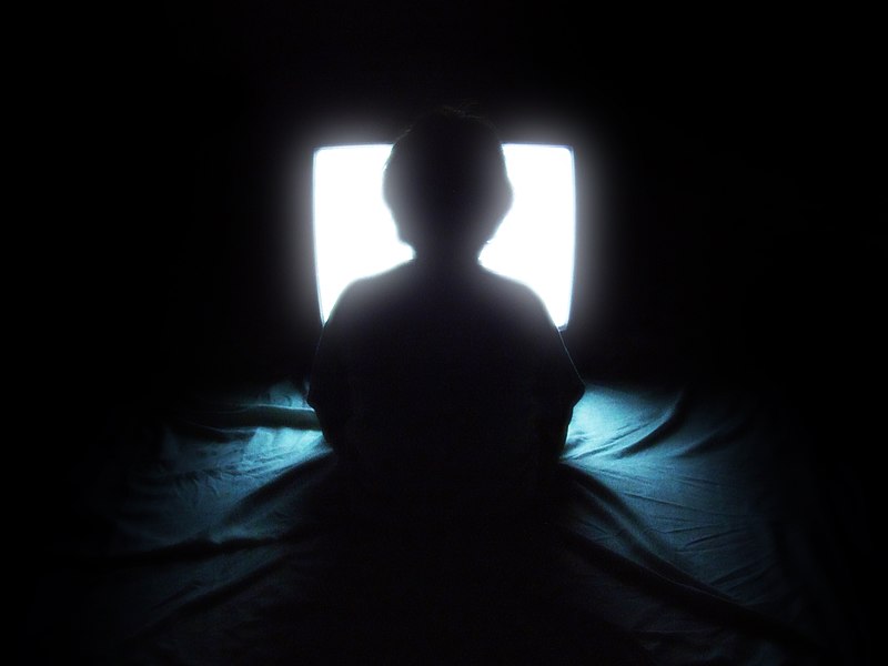 A child watching television at night