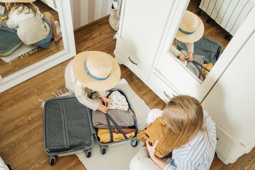 a Woman and a Child Packing a Suitcase