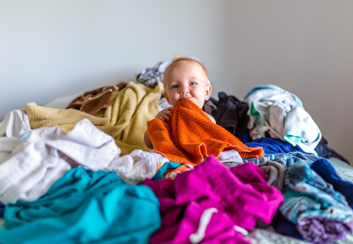 a smiling baby on a pile of laundry