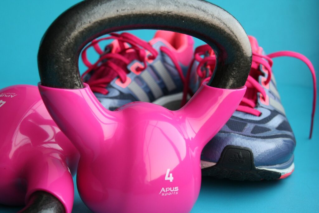 A pair of pink kettlebells with pink trainers image