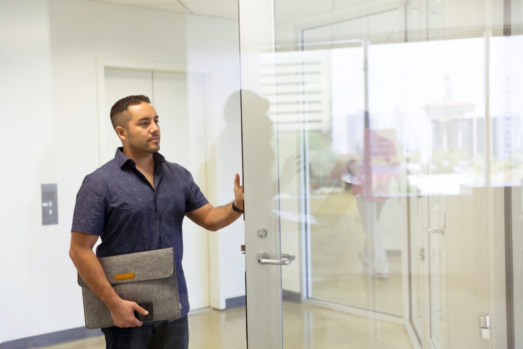 Man standing beside a glass door image