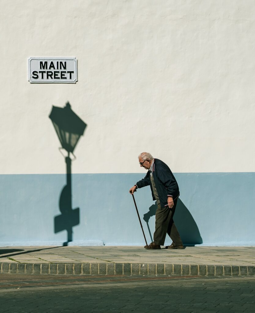 An Elderly Man Walking on the Sidewalk