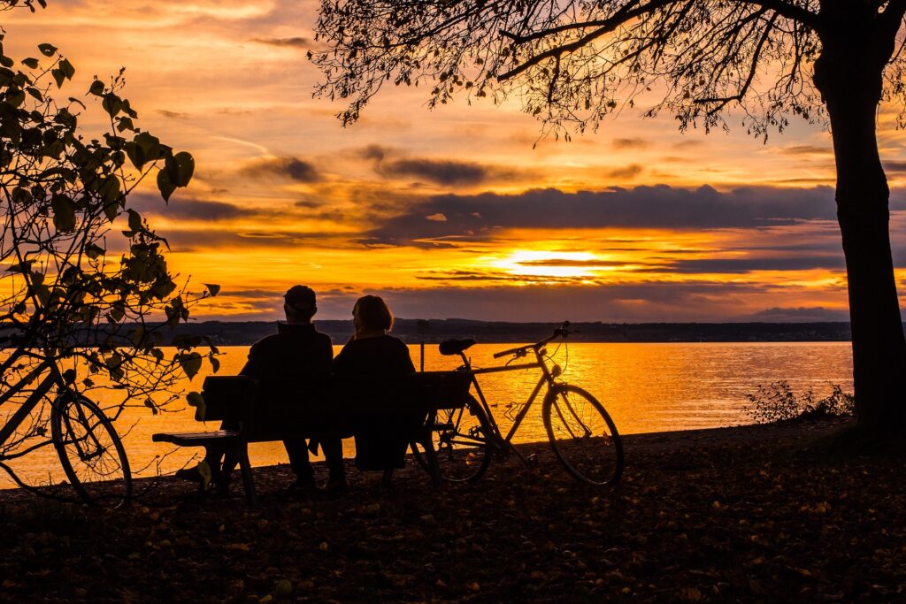 A couple enjoying a sunset by a lake