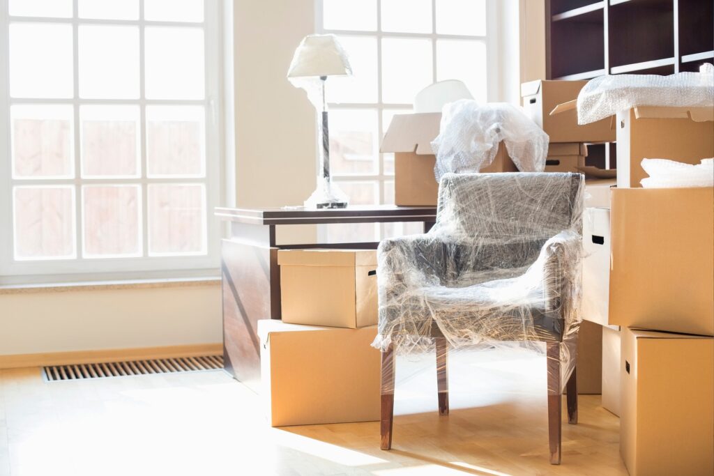 A wrapped chair surrounded by moving boxes