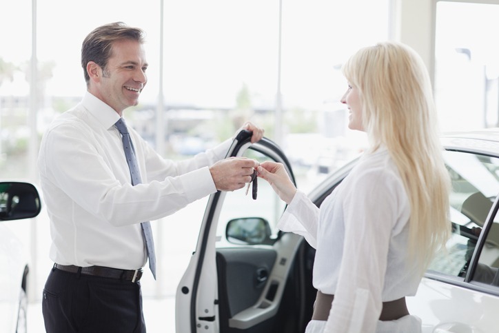 Car salesman handing keys to customer
