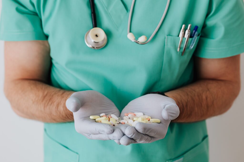 Faceless doctor with pills in hands image