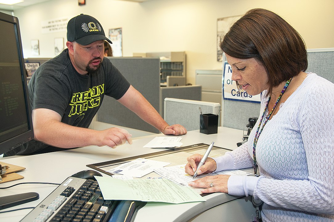 A DMV clerk helps a customer with paperwork